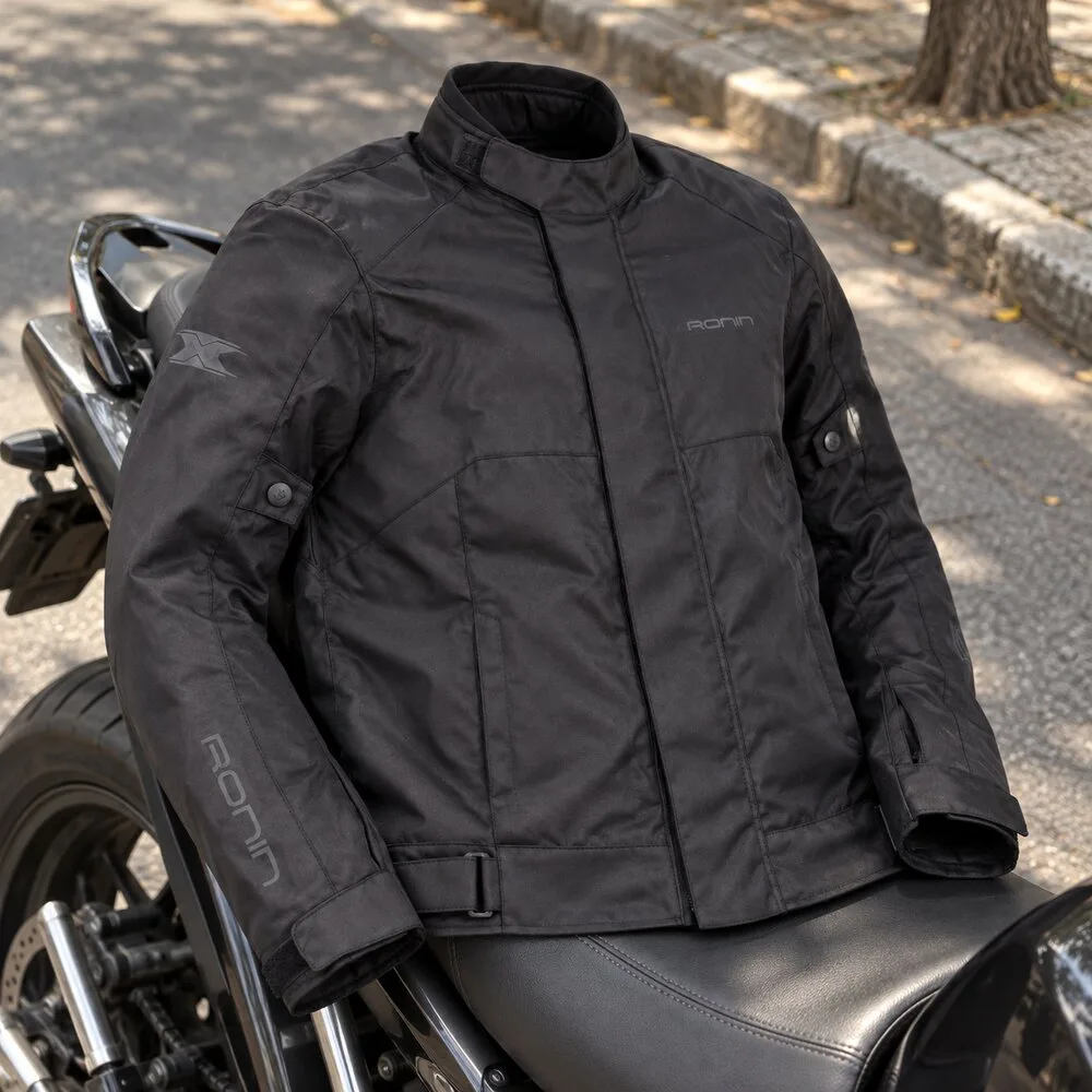 Jaqueta Texx Ronin V2 preta apoiada no banco de uma moto estacionada na rua