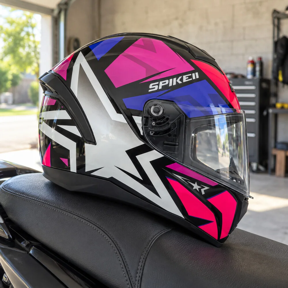 Peels Spike II de estrela rosa e prata no banco da moto, numa garagem com a porta aberta